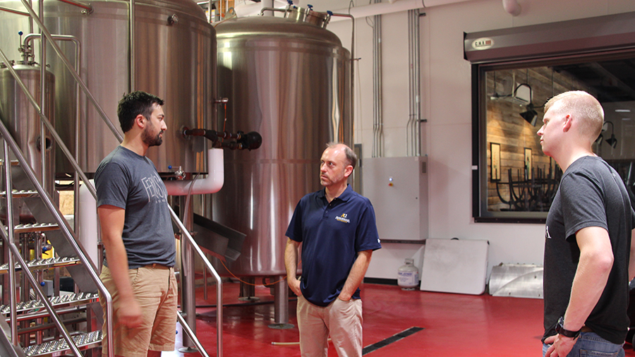 Augustana's Dr. Paul Egland and senior Dan Schmidtman visit with Fernson co-owner Blake Thompson '10