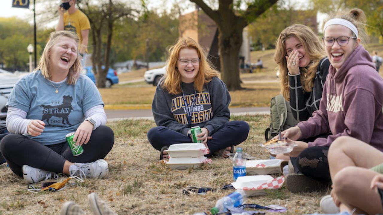 students laughing on the campus green