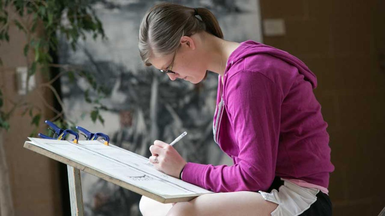 Art student sketches in the Center for Visual arts atrium