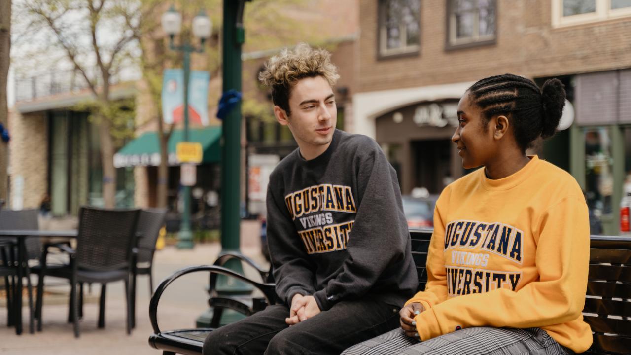 Two students talk on a bench in downtown sioux falls