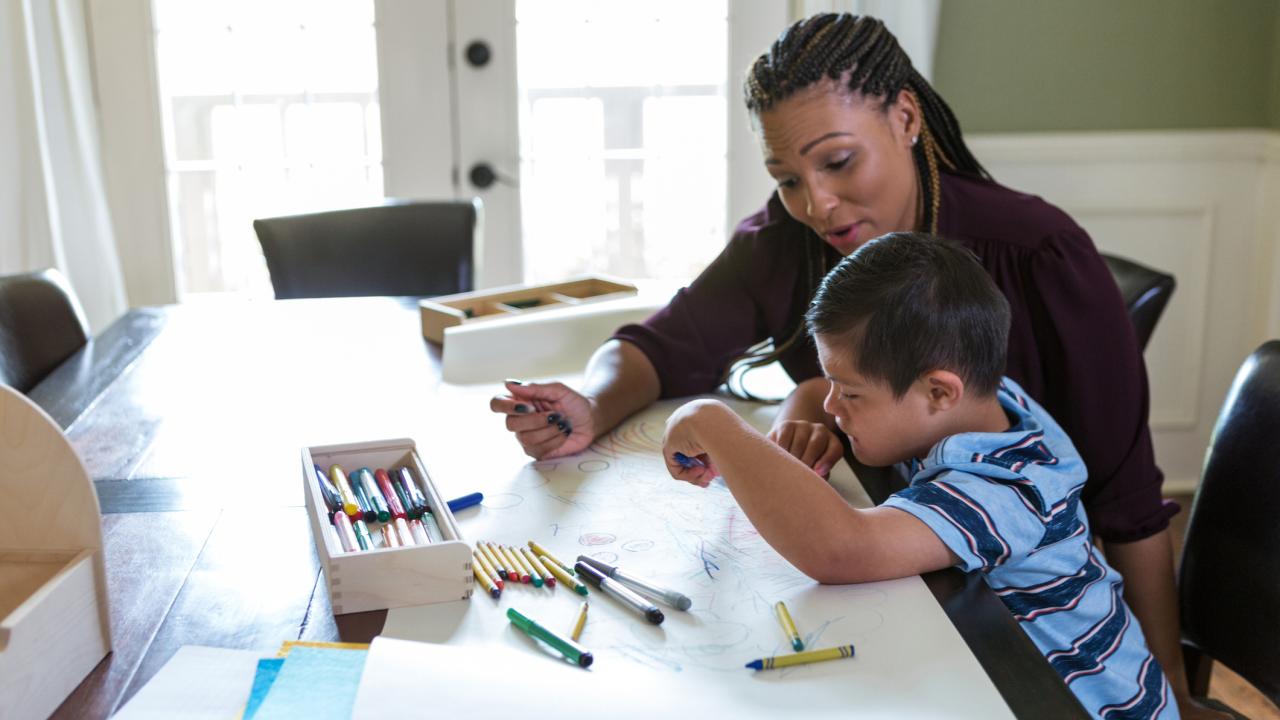 woman working with child at table