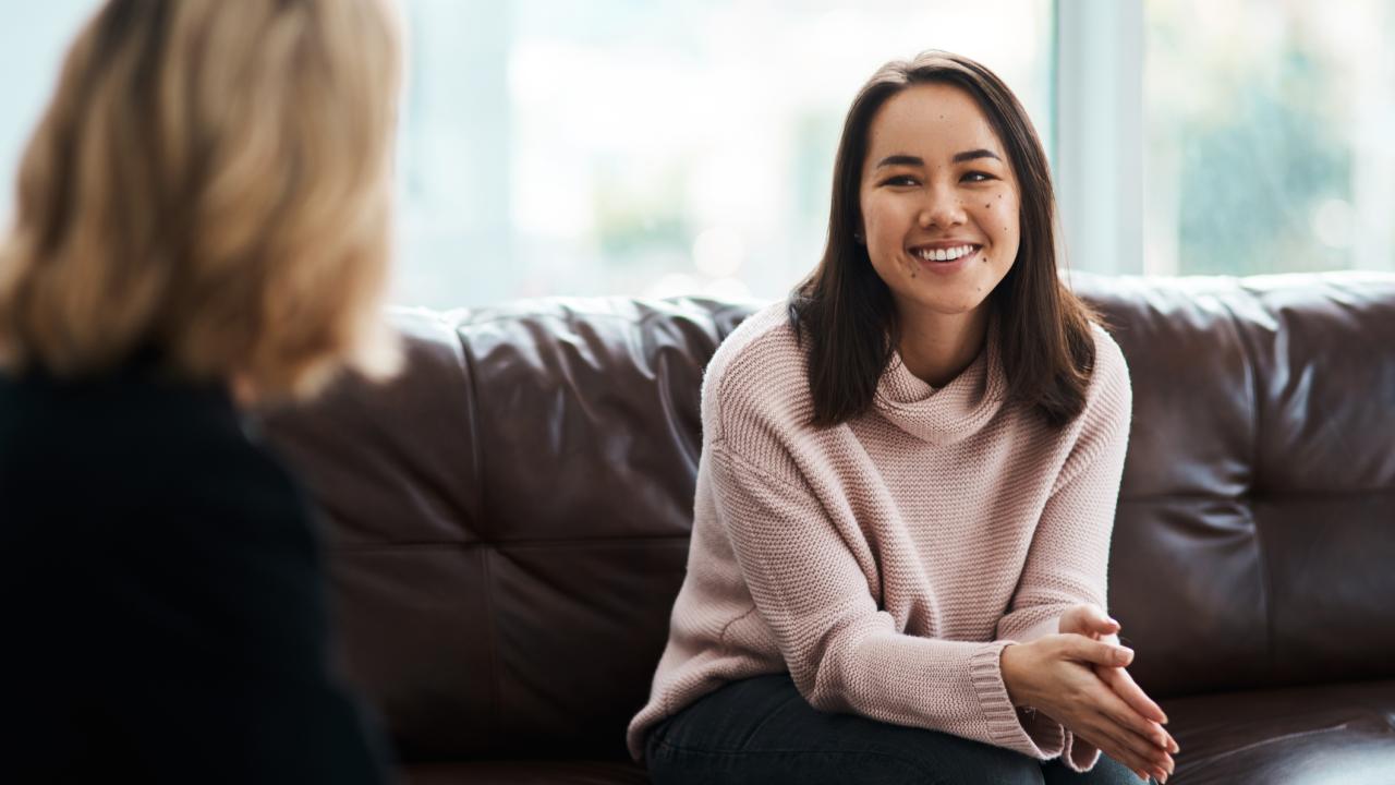 two women talking on couch