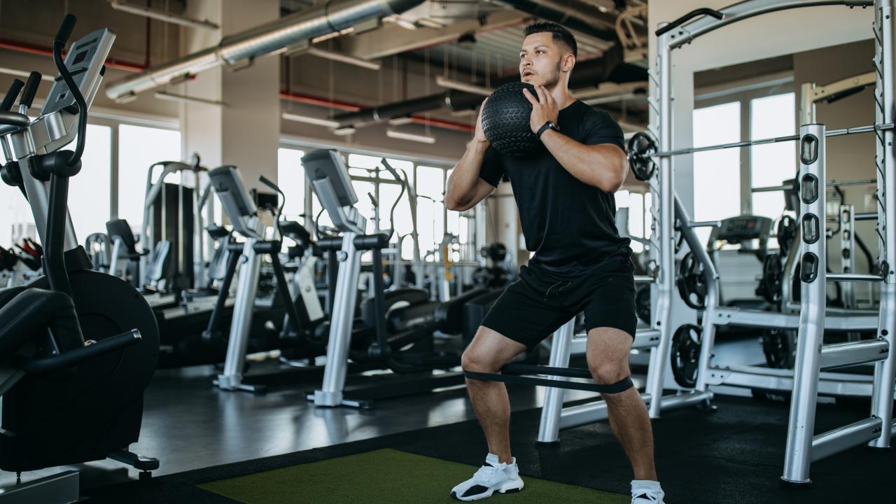 man using medicine ball in gym