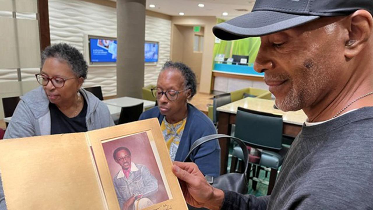 Alfred White Jr. Holds Picture of Father