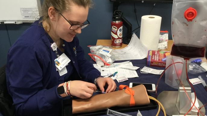 Nursing student using model for administering shot