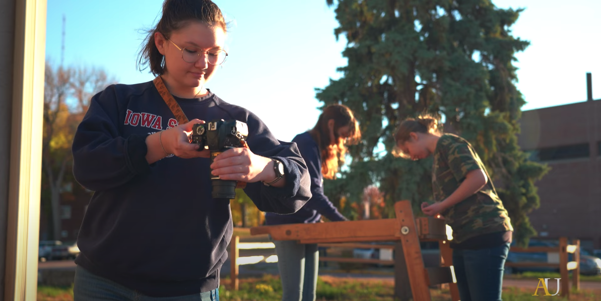 student taking photo of dig site